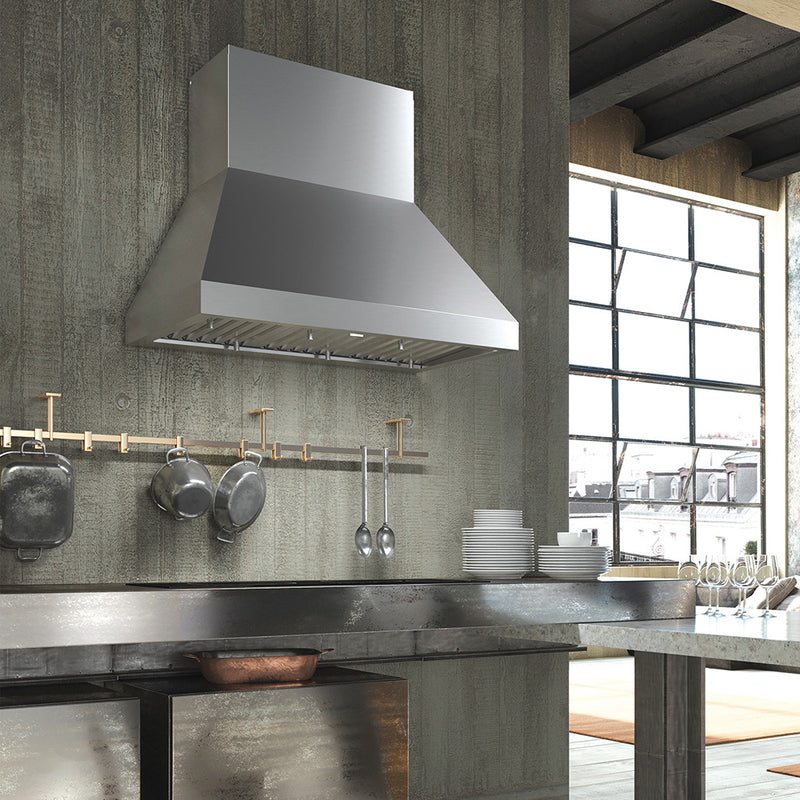 Faber Camino pro Stainless steel wall kitchen range hood in an industrial kitchen setting lifestyle image. wood panel backwall and stainless countertop