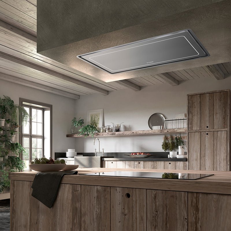 faber high-light stainless steel island & ceiling kitchen range hood with perimeter aspiration in a rustic kitchen setting