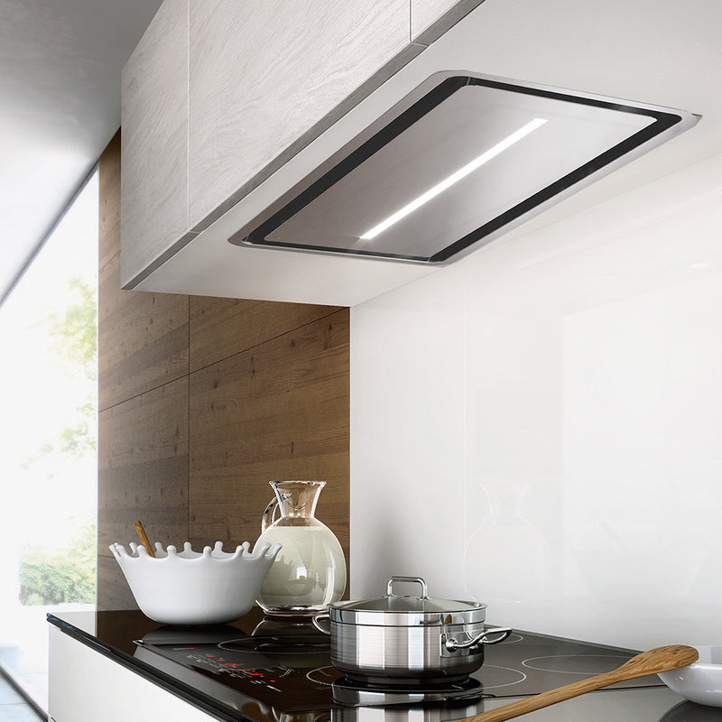 faber inca in-light stainless steel insert kitchen range hood with perimeter aspiration in a minimalist kitchen setting. rectangle shape with a centered led bar
