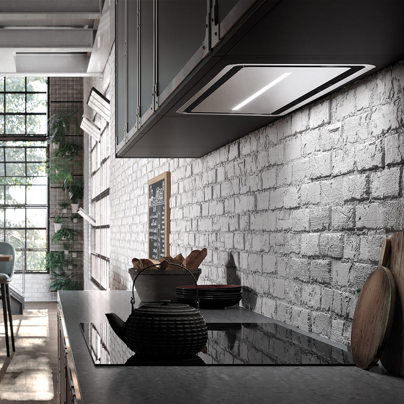 faber inca in-light stainless steel insert kitchen range hood with perimeter aspiration in a rustic industrial kitchen setting. rectangle shape with a centered led bar