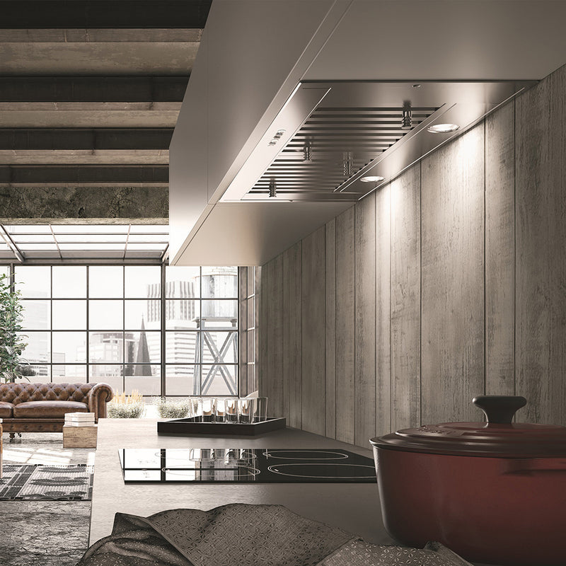 faber inca sd lifestyle image
The image depicts a modern kitchen space with an integrated range hood, an induction cooktop, and a rustic-industrial design. It includes a cozy sitting area with a leather couch and large windows providing ample natural light.