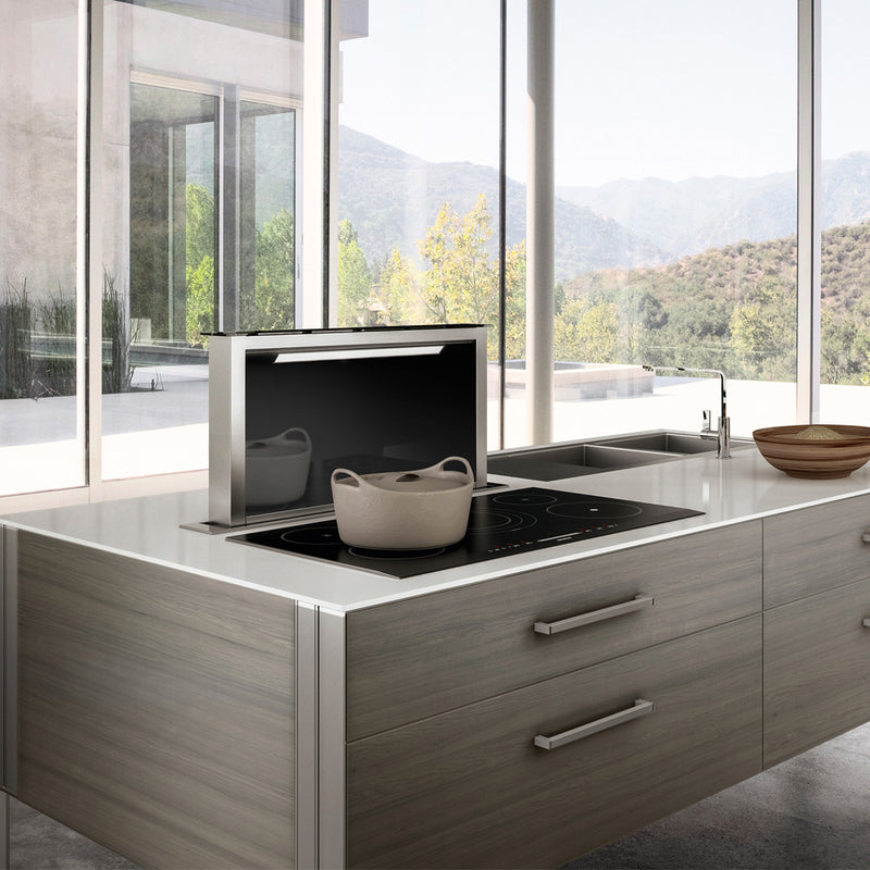 Luxury kitchen with beautiful island featuring a Faber Scirocco Lux down draft hood.